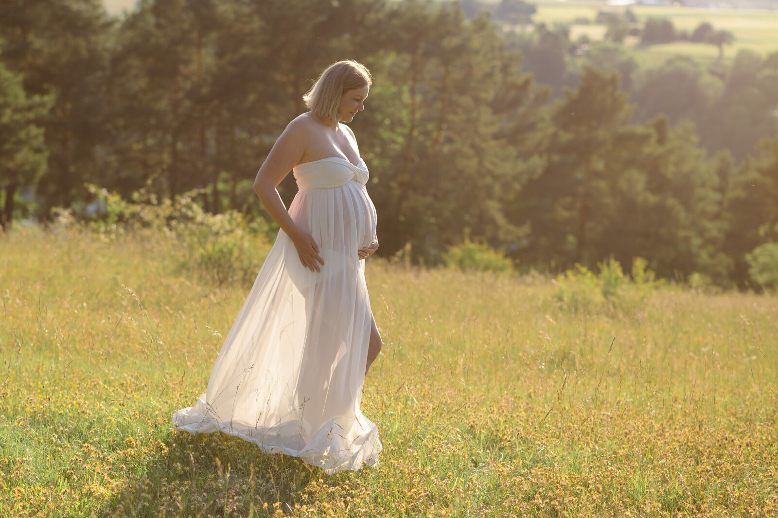 Schwangere beim Fotoshooting im Gegenlicht