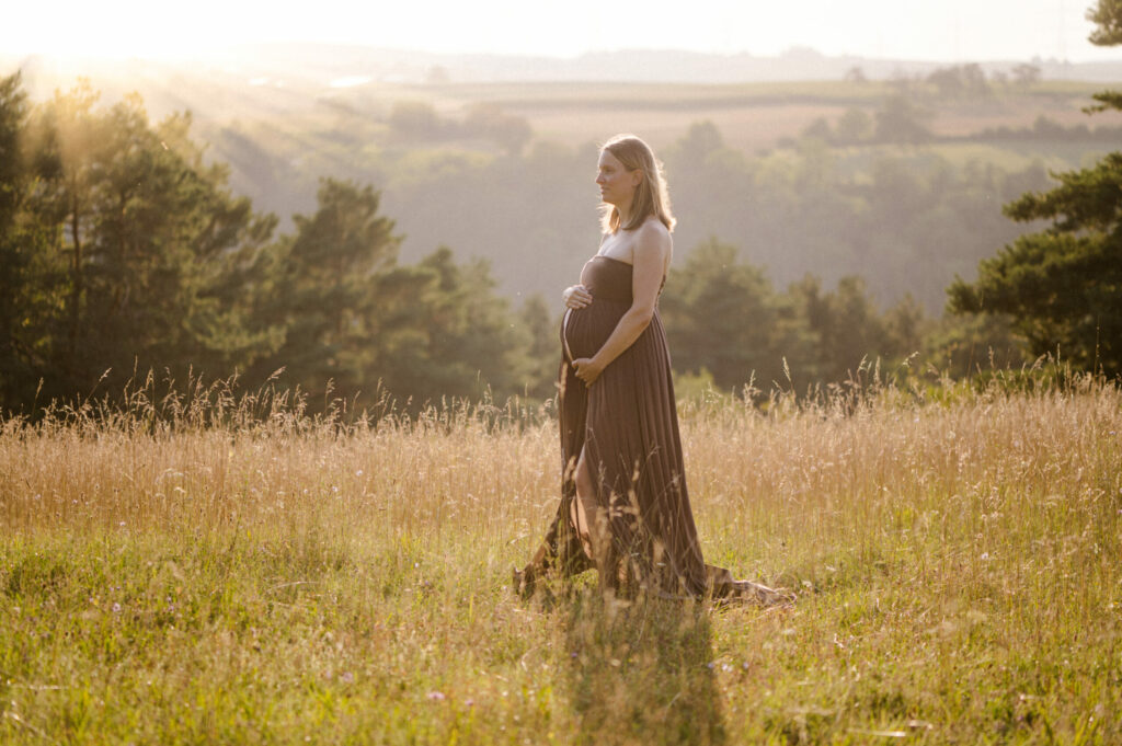 Schwangere Frau im Gegenlicht im Kleid