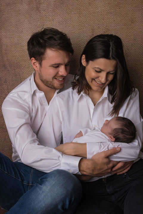 Glückliche Eltern bei der Neugeborenenfotografie