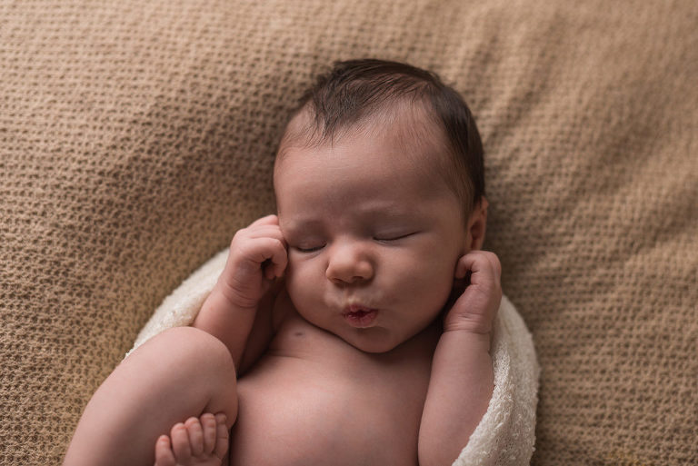 Ein entspanntes Baby beim Fotoshooting. zarte Neugeborenenfotografie