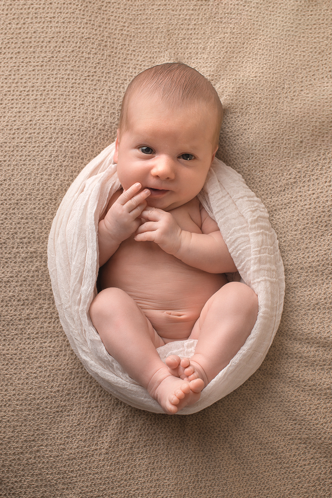 Neugeborenes Baby liegt auf einer Decke