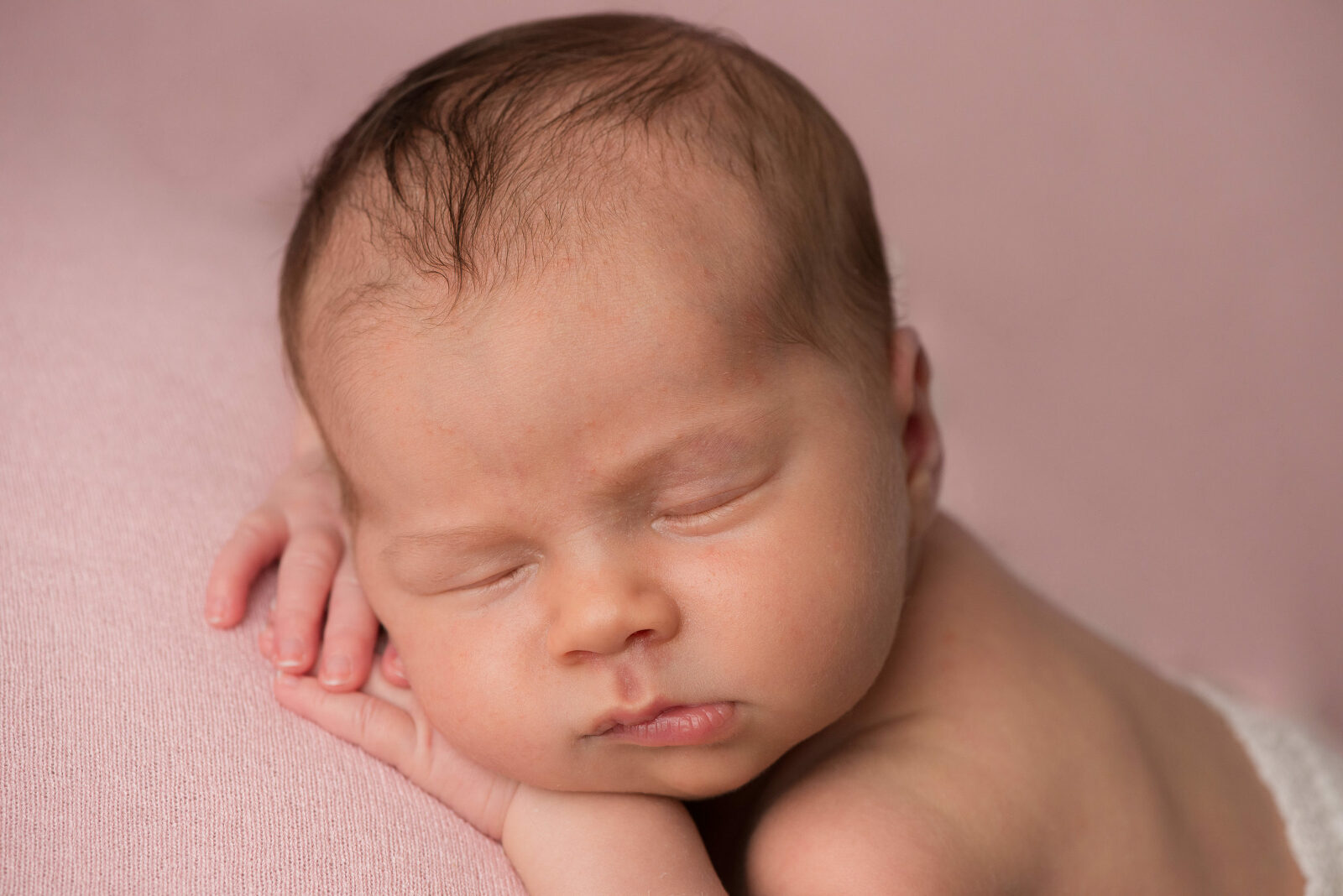 Neugeborenes Baby liegt schlafend auf dem Bauch