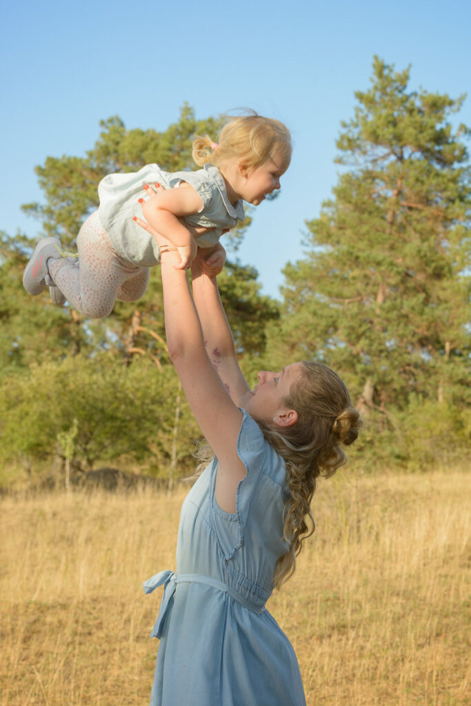 Mutter wirft ihr Kind in die H&ouml;he im Spiel