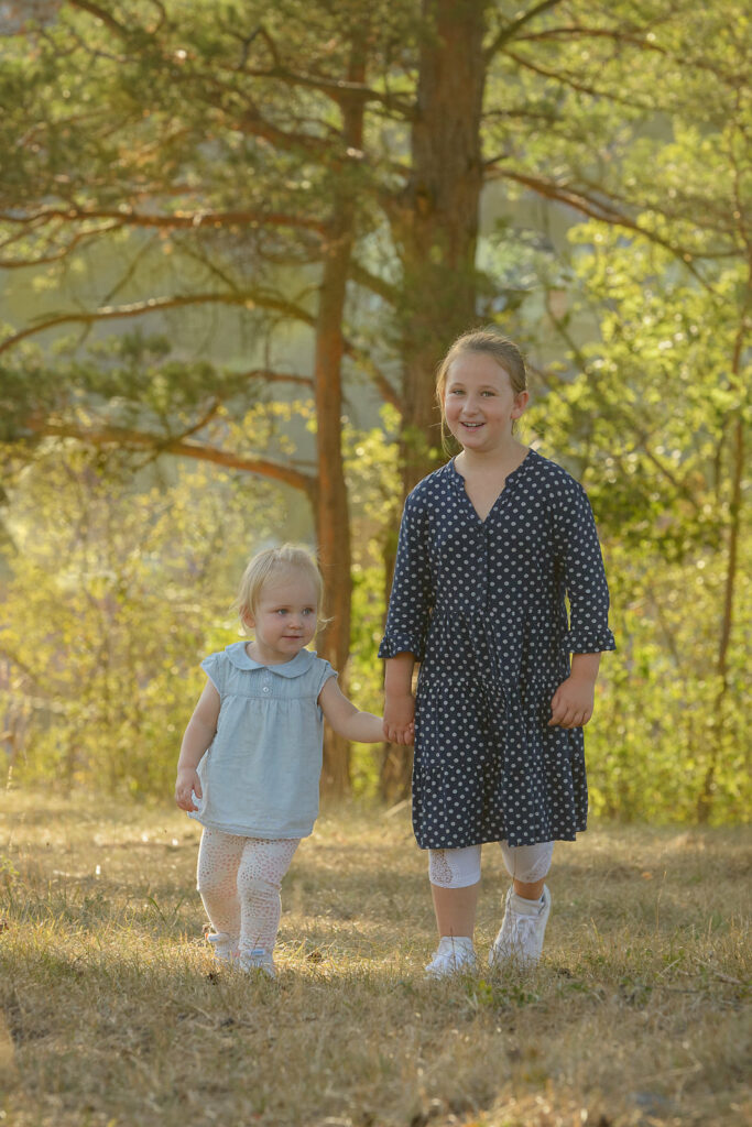 Geschwisterkinder laufen auf einer wiese Hand in Hand