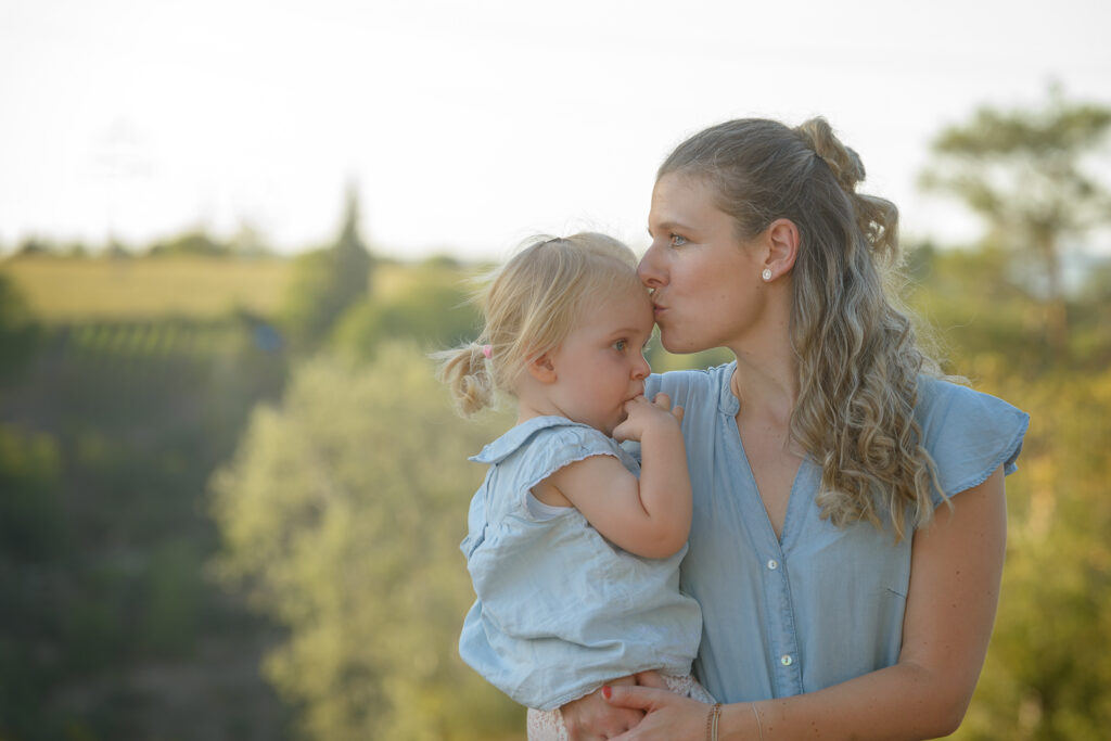 Mutter k&uuml;sst Tochter sanft auf die Stirn familienfotoshooting Ludwigsburg Abendlichtstimmung
