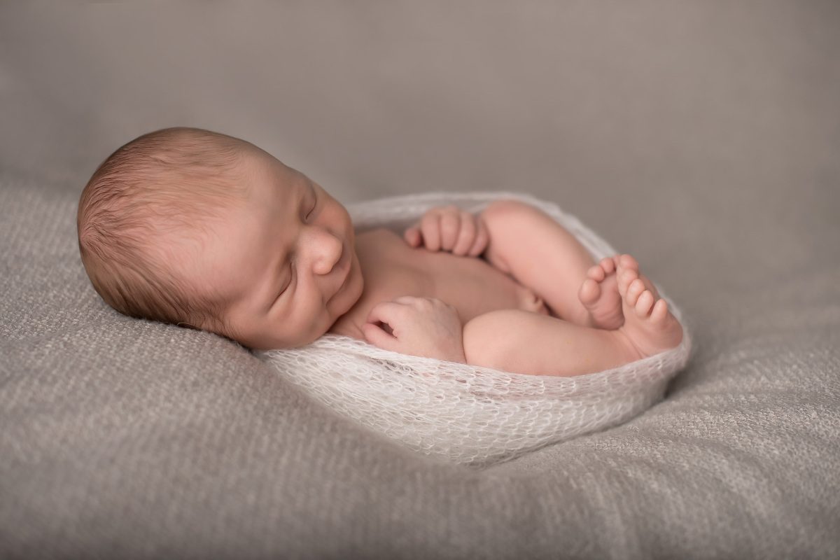 Neugeborenes Baby liegt auf einer Decke