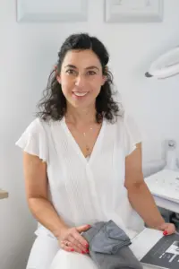 Brandingfotografie &ndash; Portrait einer Kosmetikerin im Studio, sitzend, hell gekleidet