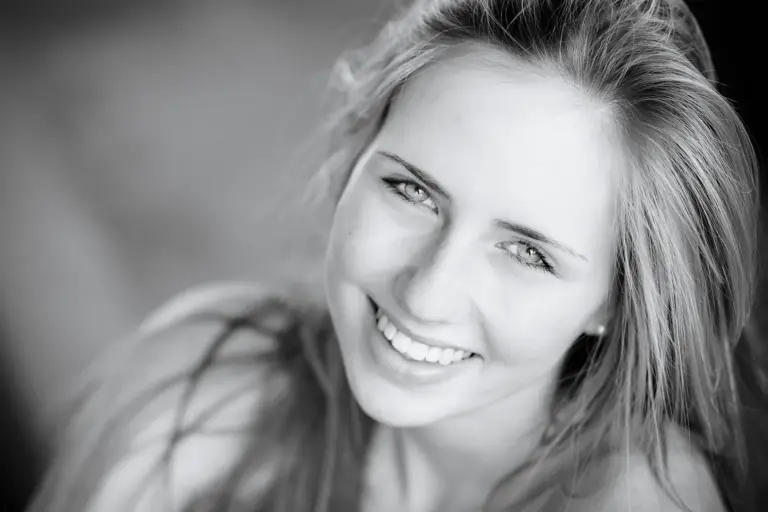 L&auml;chelnde junge Frau mit langen blonden Haaren, Schwarzwei&szlig;