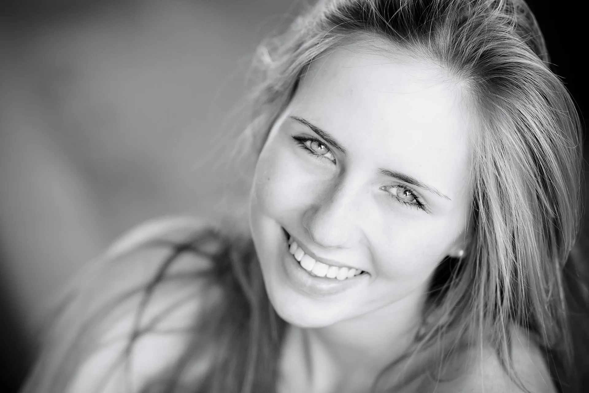 L&auml;chelnde junge Frau mit langen blonden Haaren, Schwarzwei&szlig;