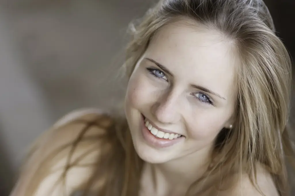 Lächelnde junge Frau mit langen blonden Haaren - color