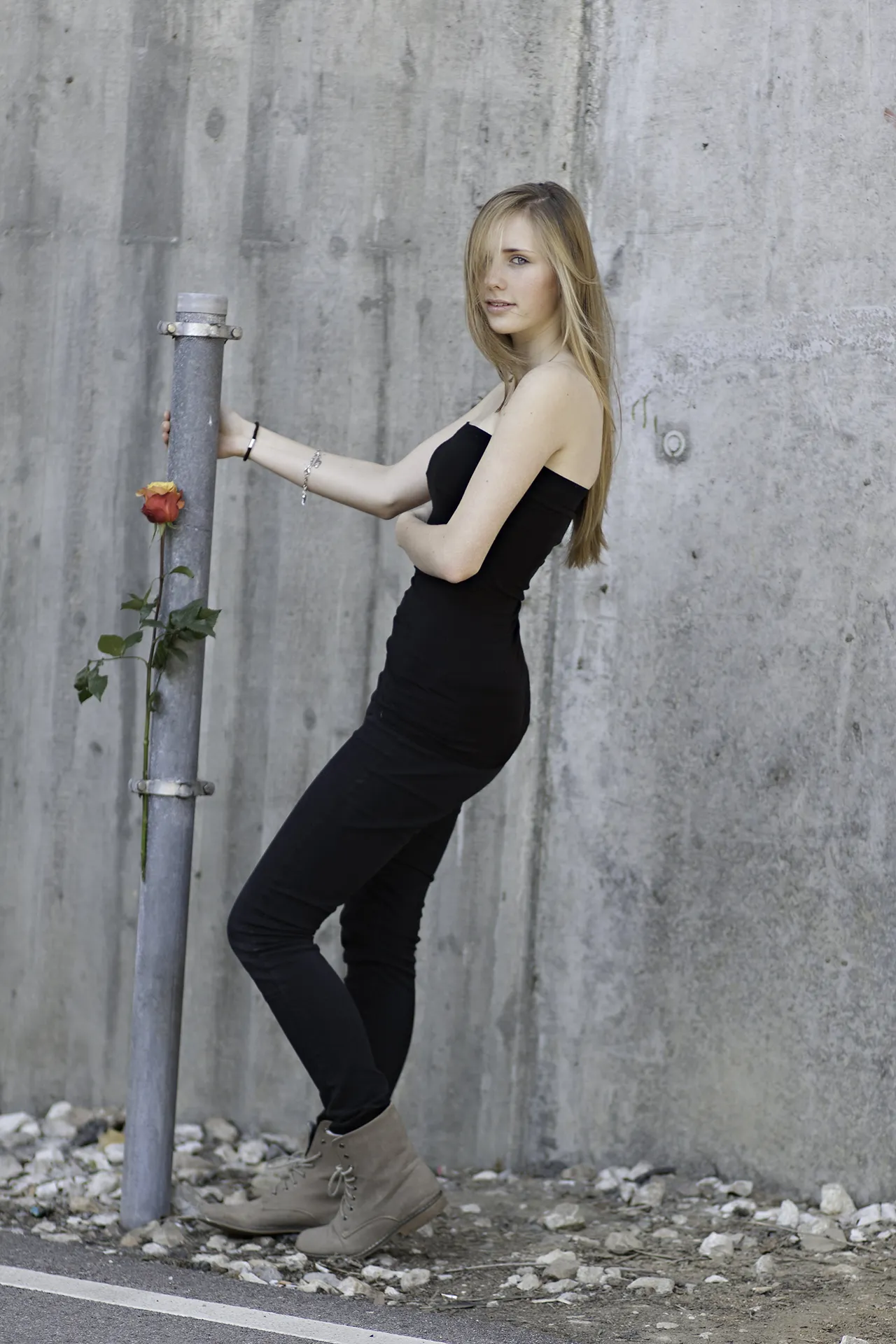 Blonde junge Frau, stehend, l&auml;chelnd mit Rose, in l&auml;ssiger pose sanftes Licht