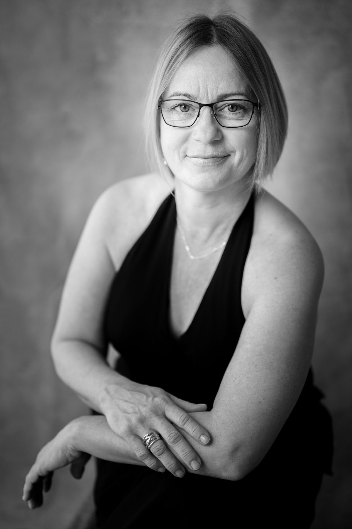 Frauenfotografie im Studio – sitzendes Portrait im schwarzen Kleid