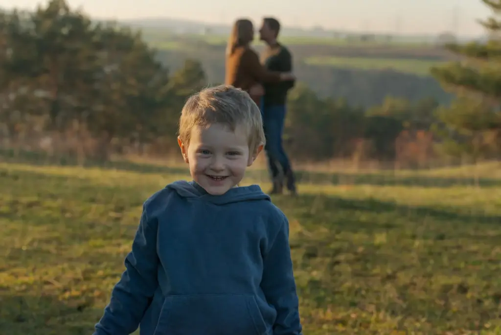 Kind im Vordergrund, Eltern zusammen im Hintergrund, liebevolle Familienaufnahme Sersheim