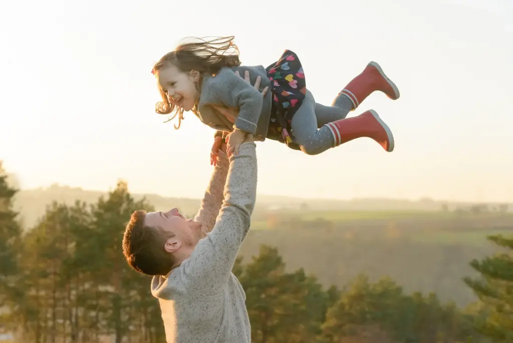 Papa l&auml;sst Tochter in die Luft fliegen, fr&ouml;hlicher Moment, Outdoor Familienfotografie Vaihingen-Enz